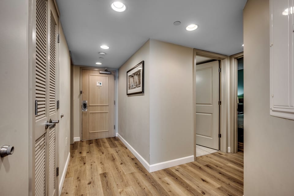 Welcoming hallway with wood floors, neutral walls & modern recessed lighting