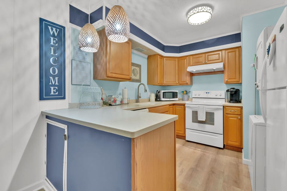 Full Kitchen with an electric stove, microwave, dishwasher, & refrigerator. 