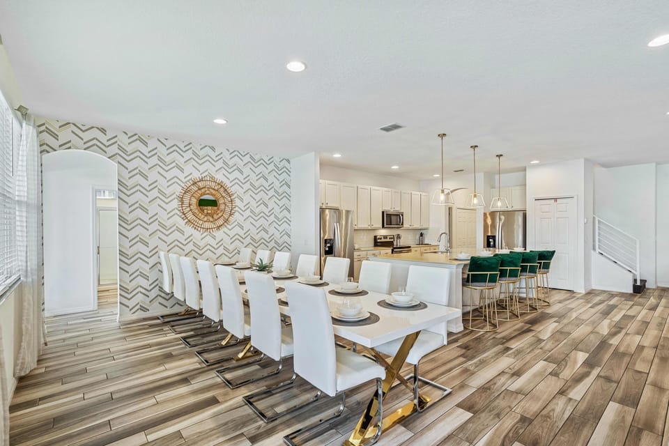 - Vacation rental with modern kitchen and long dining tables  
- Seating for large groups and stylish accents throughout space  
- Orlando home rental with chef-ready kitchen near theme parks