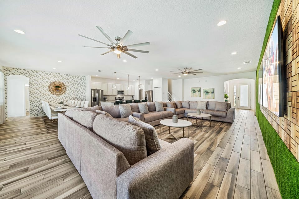 - Large open living area with modern décor and dining setup  
- Sectional couches and spacious design for family gatherings  
- Vacation home near Disney with bright and inviting interiors