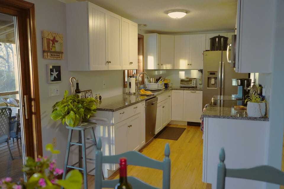 A well-equipped kitchen features granite countertops, and a range of appliances.