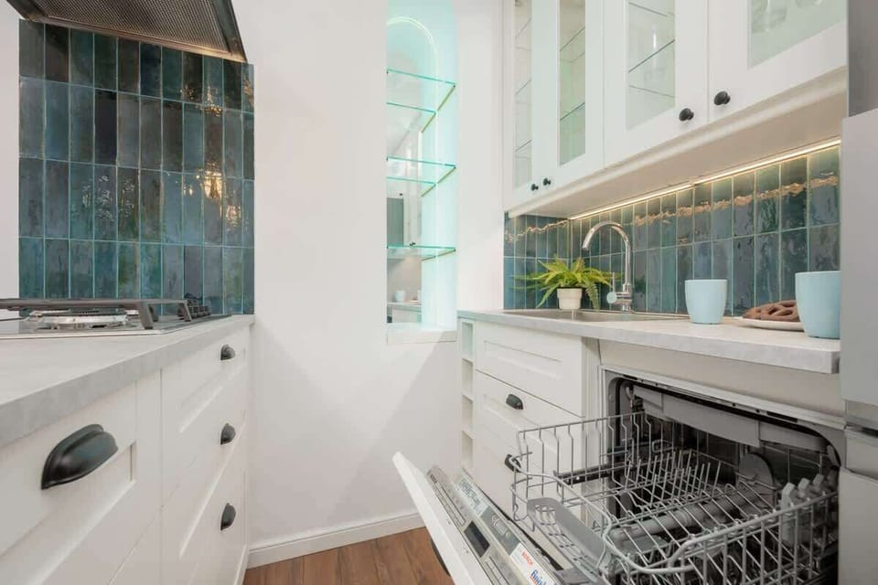 Fully equipped kitchenette with gas cooktop, electric kettle, refrigerator with freezer, dishwasher, oven with microwave option, set of dishes, kitchen utensils and dining area
