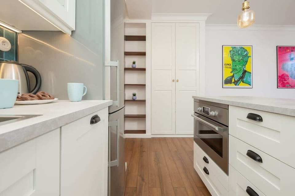 Kitchenette with gas cooktop, electric kettle, refrigerator with freezer, dishwasher, oven with microwave option, set of dishes, kitchen utensils and dining area