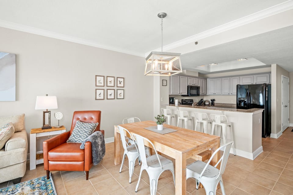 Dining area that has a table with seating for 4, a bar area with seating for 4 and an AMAZING Gulf view