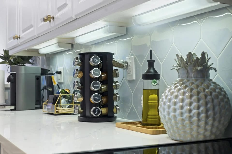 Modern kitchen countertop with a rotating spice rack and olive oil dispenser.