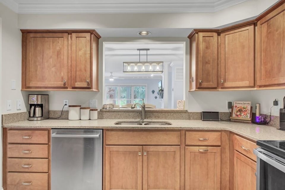 - Enjoy cooking with a view thanks to the open pass through and soft natural light - Warm wood cabinets, full size appliances, and thoughtful touches make meals easy - Whether you're meal prepping or making mimosas, this kitchen has your back