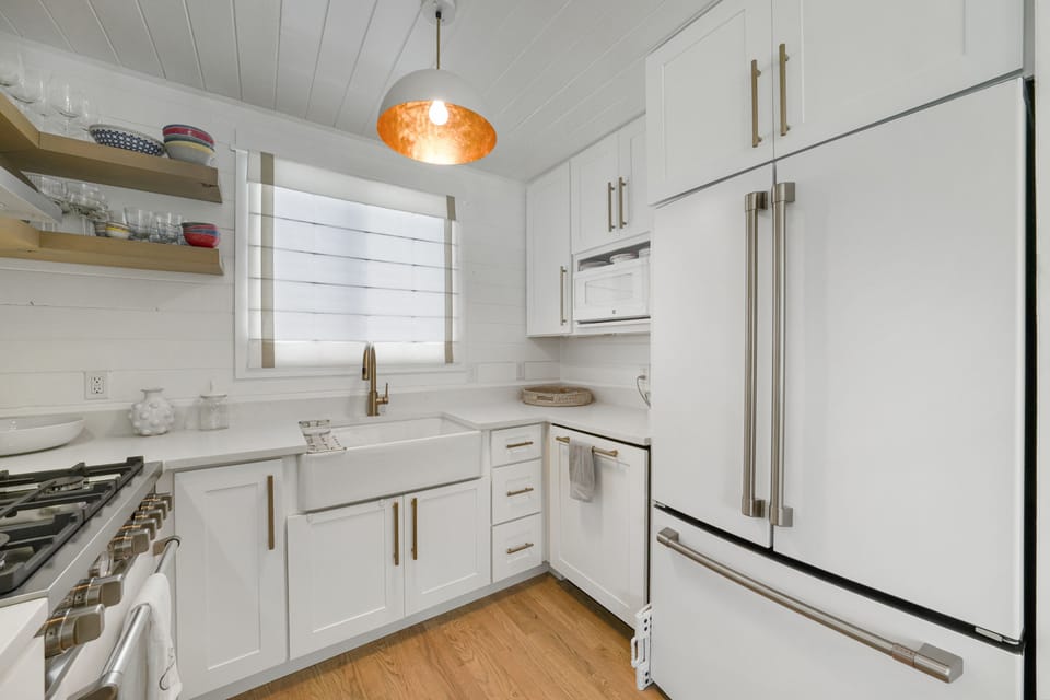 KITCHEN VIEW TO LARGE FRIDGE, FARMHOUSE SINK, & GAS STOVE
