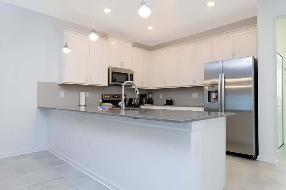 Modern fully-equipped kitchen with stainless steel appliances.