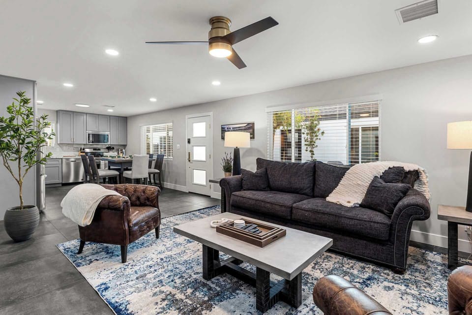 Casa Principal open plan living room with plush couch and leather chairs.