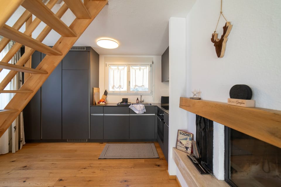 Modern kitchen with fireplace and open wooden staircase