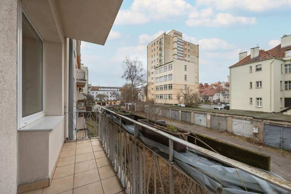 A scenic view from the balcony, overlooking the city with a mix of modern and traditional buildings, adding a dynamic urban feel.

