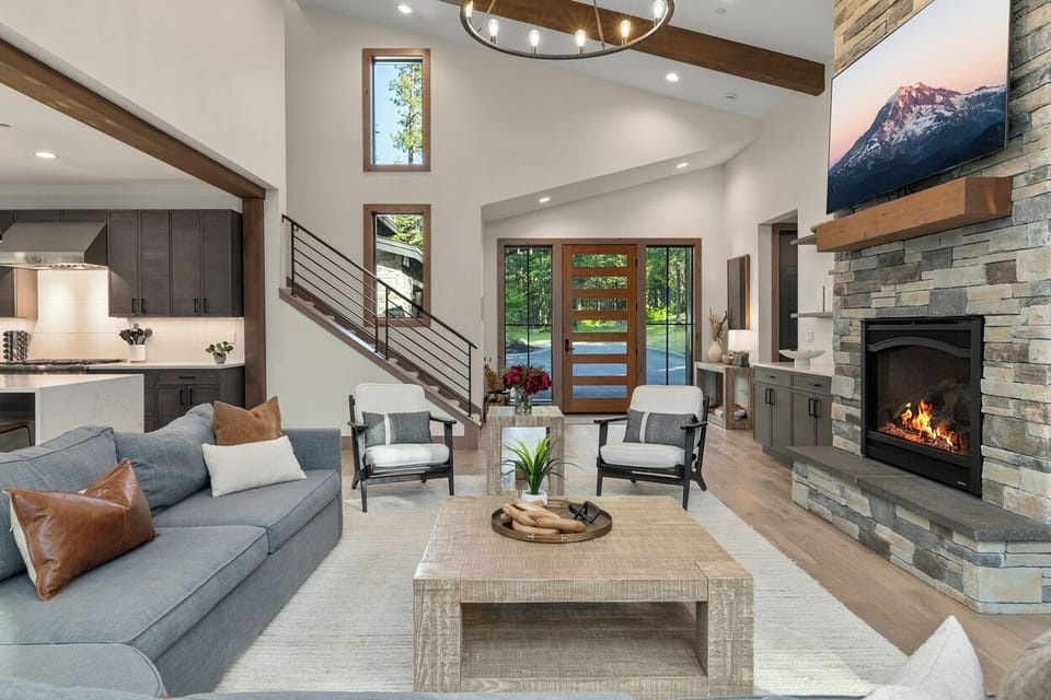 Great Room – Soaring Ceilings, Stone Fireplace, Designer Furnishings, and Open-Concept Layout.