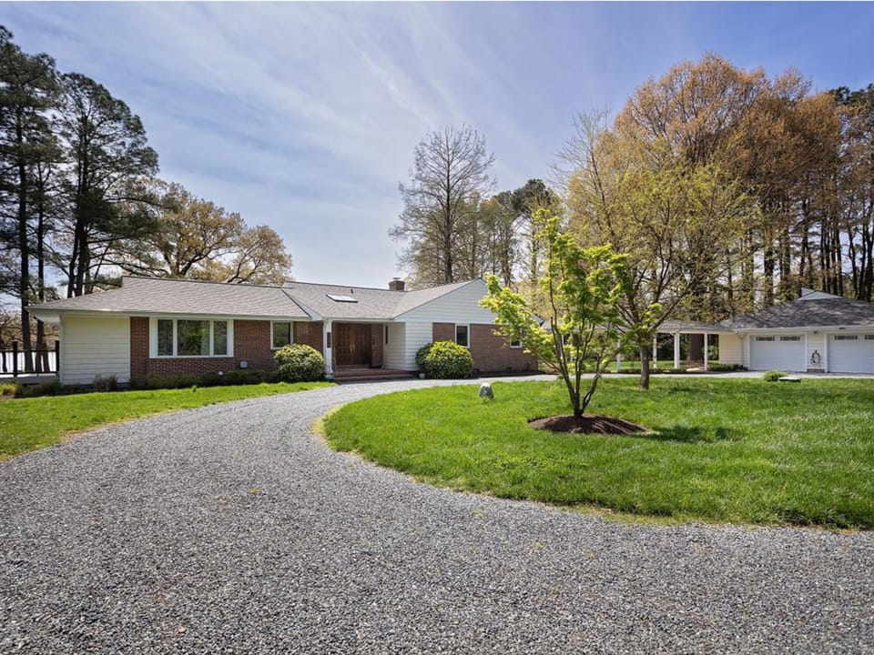 Spacious ranch-style property sits on beautifully landscaped grounds with mature trees and well-maintained lawn areas throughout the expansive outdoor space.