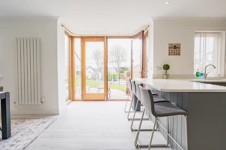Kitchen/Dining Room: the well equipped kitchen and dining space has lovely big doors looking out onto the patio area complete with seating and the luscious green garden.
