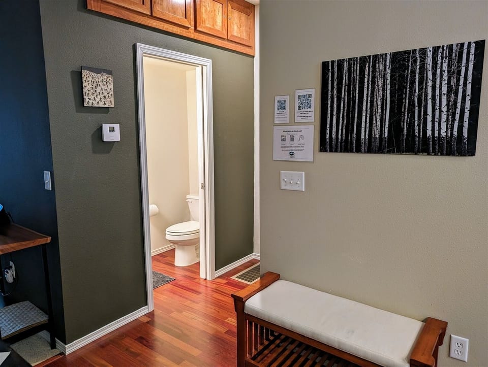 Powder room bathroom entrance and general guest information at top of entry stairs.