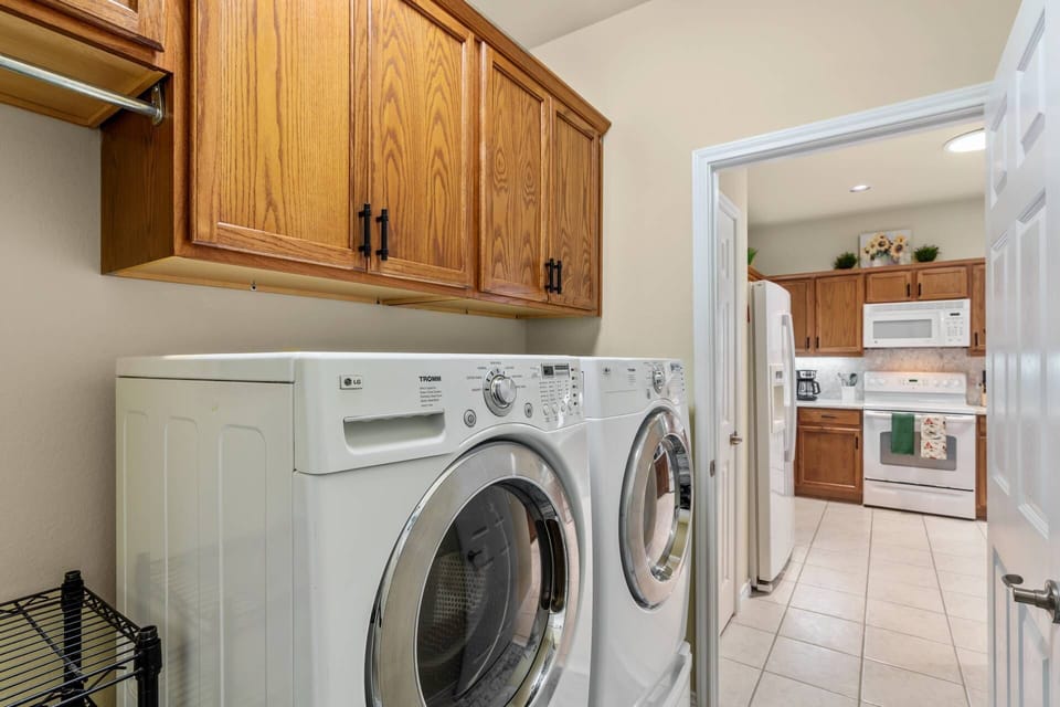 Laundry Room with Washer and Dryer and Cabinets for supplies.