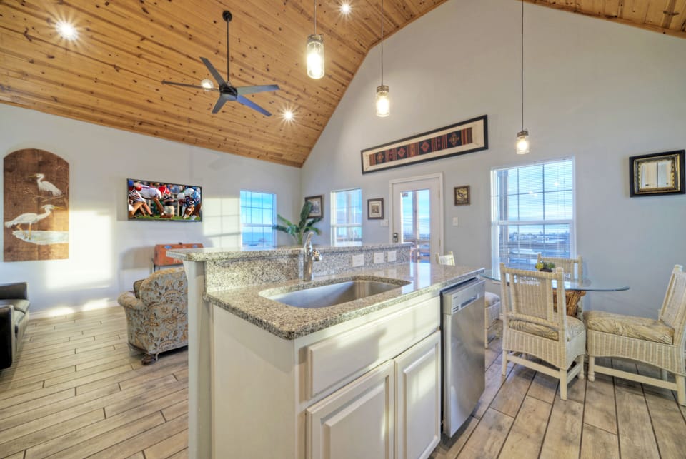 Bright, sun-soaked interior with a stunning rustic wood ceiling.