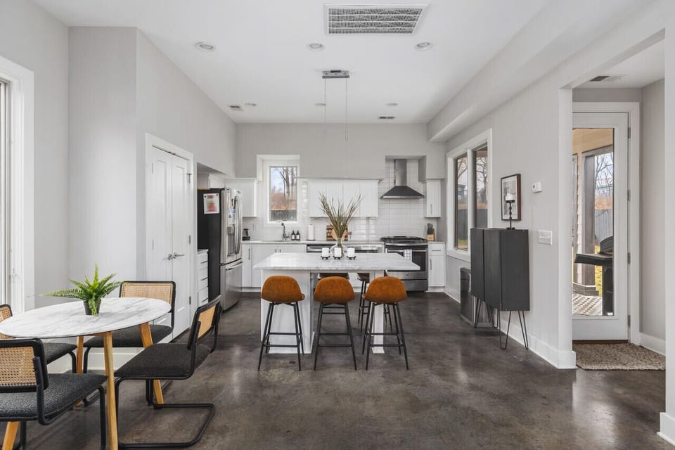 Open floor plan leading from the living room to kitchen & dining areas. Dining table with seating for 4 plus an additional seating area for 6 at the kitchen island.