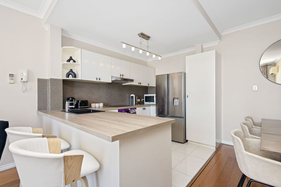 Prepare delicious meals in this open-plan kitchen, complete with modern appliances, ample counter space, and a breakfast bar for casual dining.