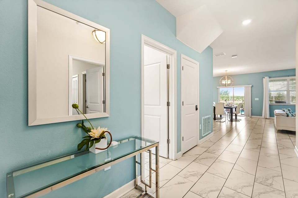 Inviting hallway leading to a bright dining area with modern decor and ample natural light.