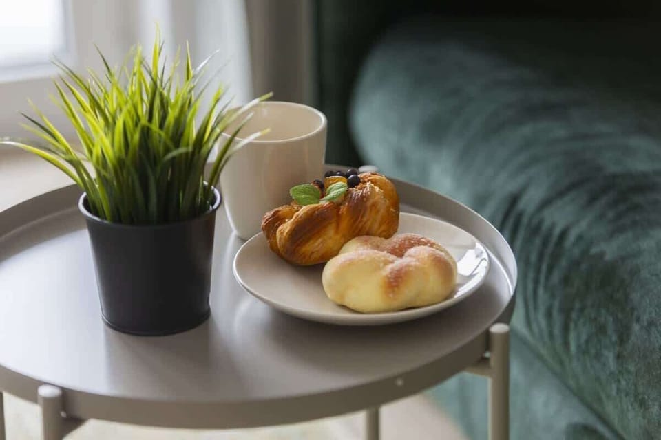 A close-up of a decorative coffee table with a potted plant and a bowl of fresh fruit, adding warmth and a natural touch to the interior.

