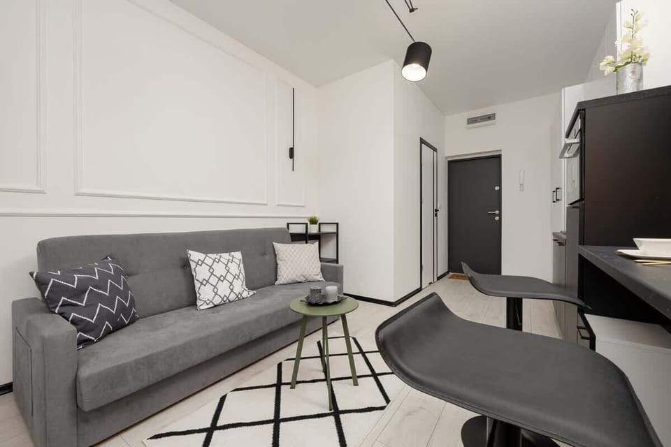 A different perspective of the living room, emphasizing the open space, stylish gray sofa, and black accents that add depth to the design.

