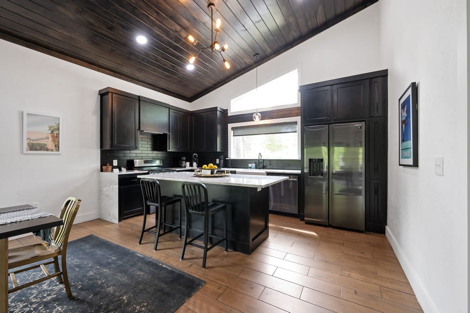 Continuing around the corner you'll see the spacious kitchen equipped with all modern major appliances and a large island for prep and additional dining space.