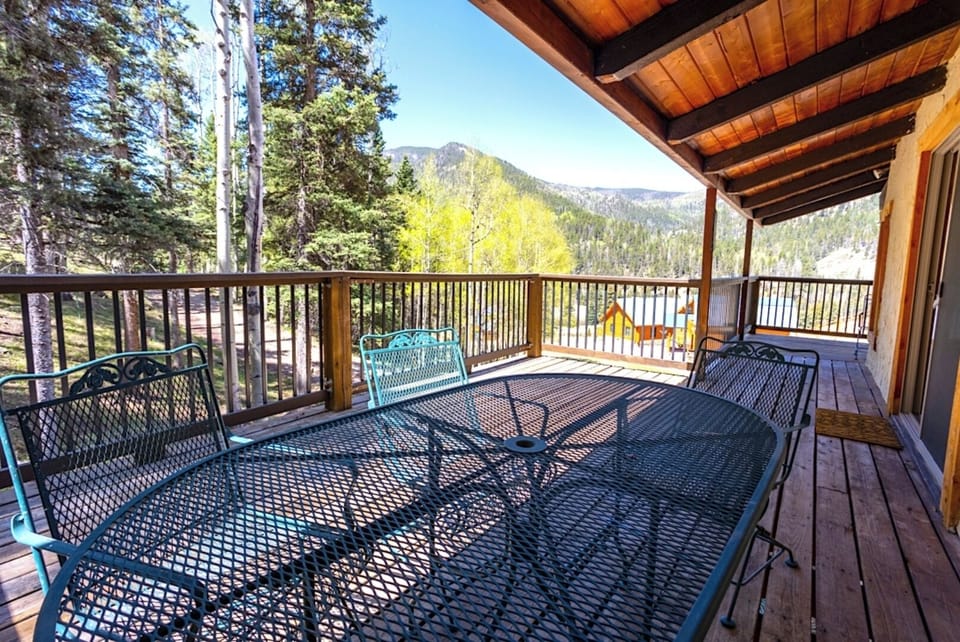 A covered deck overlooking forested slopes and distant peaks—a peaceful spot to start your mornings or unwind after exploring the surrounding area.