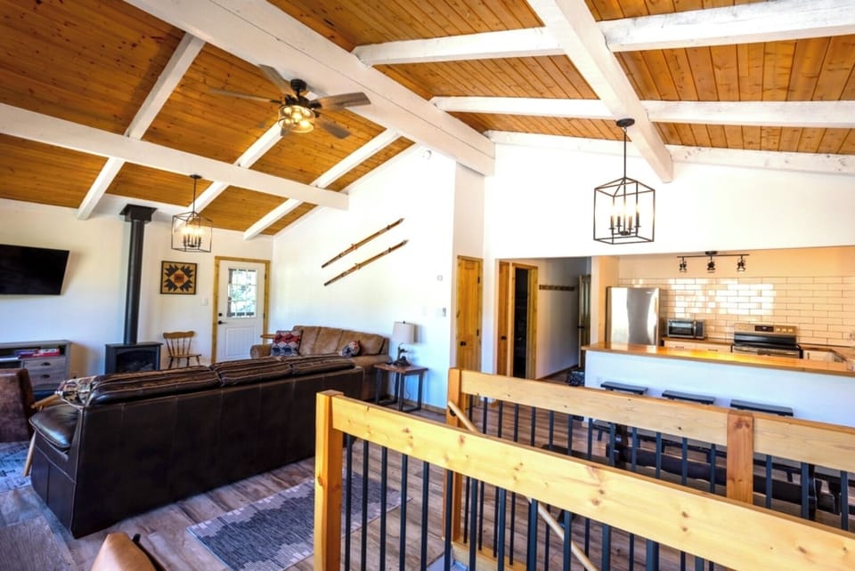Gather with loved ones in this warm open-concept space, where vaulted wood-beam ceilings and a cozy fireplace make every moment feel like a retreat.