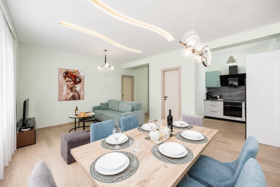 Open-plan living room with sofa, dining area, kitchen, A/C, WiFi internet, and satellite TV