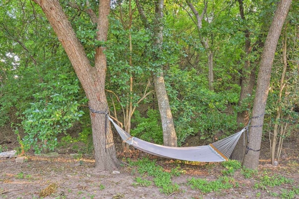 Unwind and recharge in the serene surroundings of the backyard, featuring a spacious patio, cozy hammock, and inviting fire pit