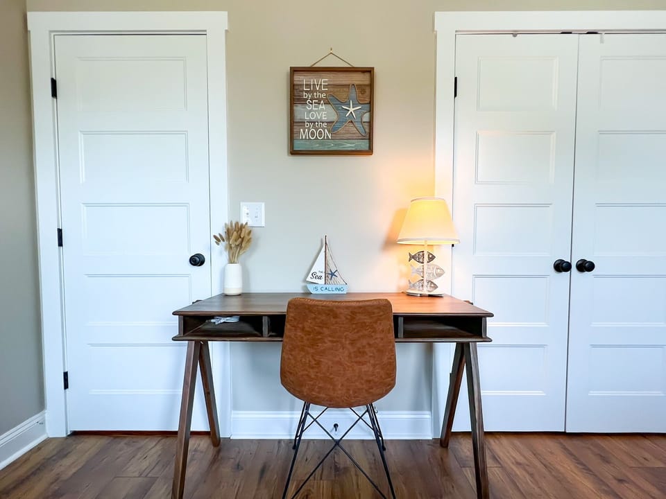 Large desk and chair located in the bedroom with 2 queen beds. 