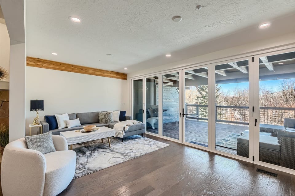 Unwind in this modern living space with an oversized sectional, large TV, and full sliding glass doors that open to mountain views and a private deck.