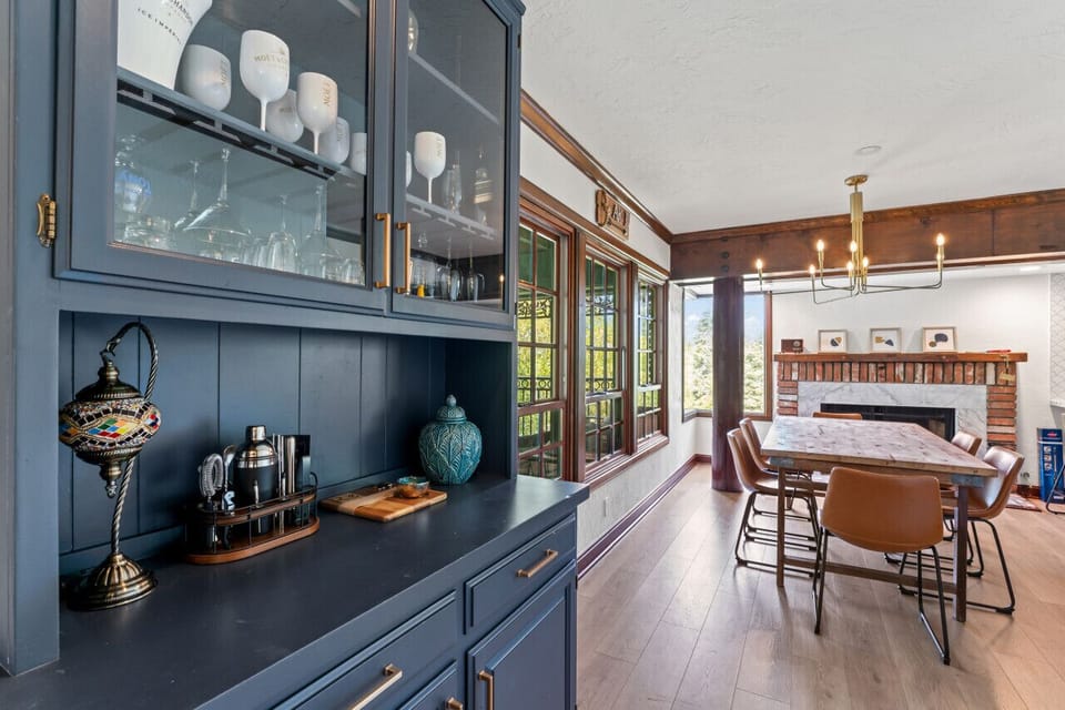Dining area w/ built-in shelving & large windows that fill the space w/ natural light.