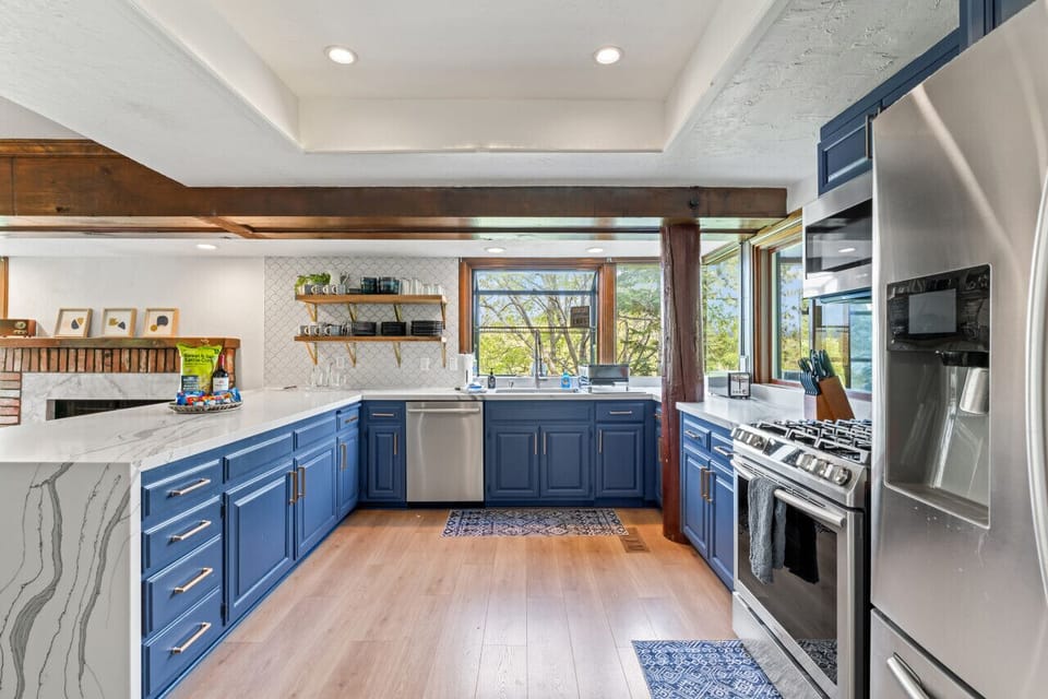 Stylish kitchen w/ blue cabinetry, stainless steel appliances & generous counter space.