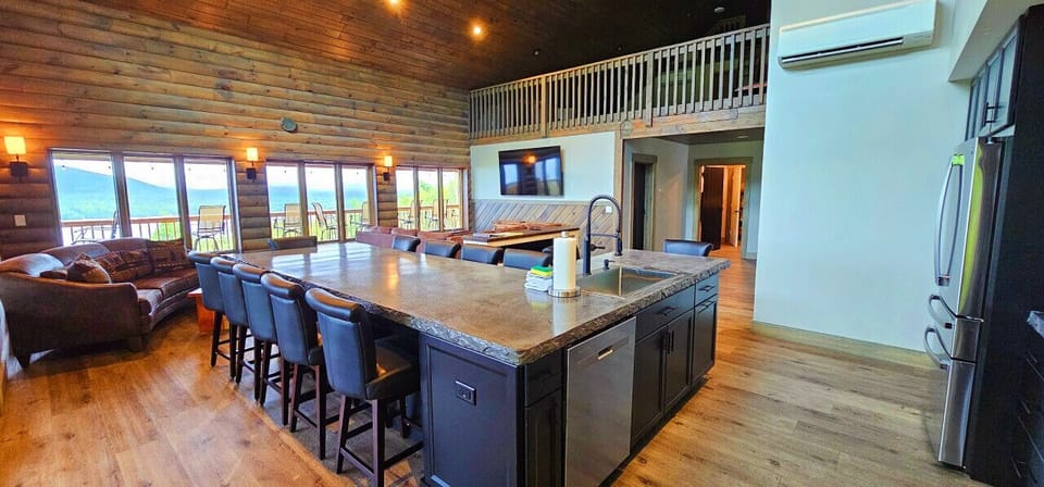 Open-concept great room with a spacious kitchen island, vaulted ceilings, and mountain views.