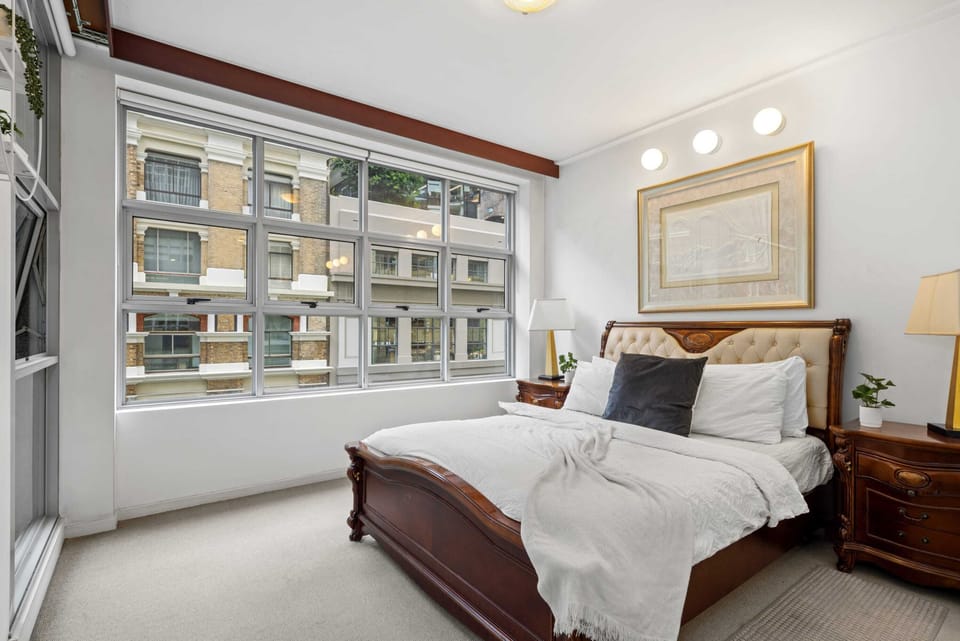 A large bedroom with a queen sized bed & plush pillows.