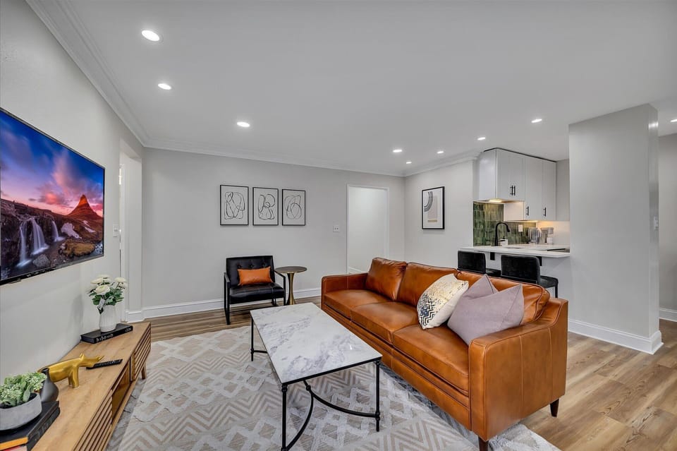 Stylish seating nook w/ leather sofa, accent chair & minimalist decor