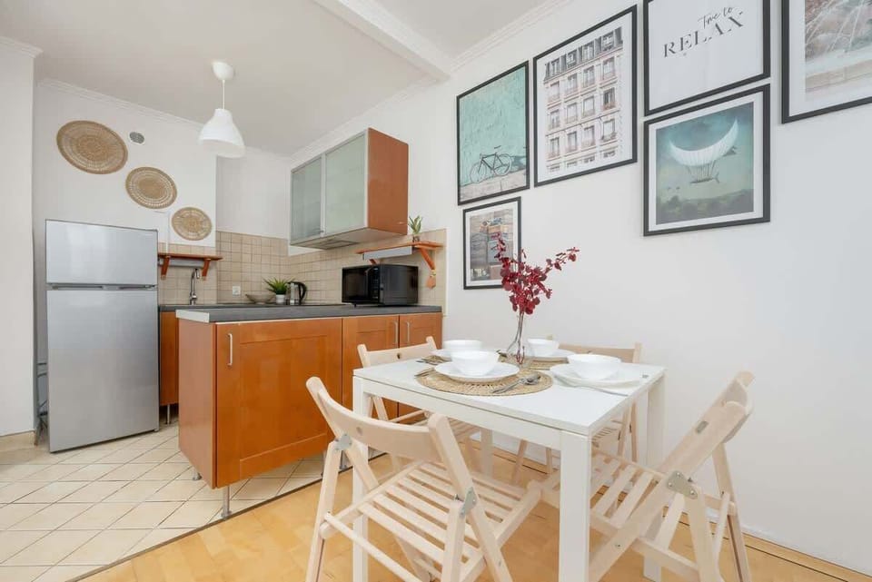 A wider view of the open-plan kitchen and dining area, highlighting the modern appliances, white cabinets, and stylish decor.

