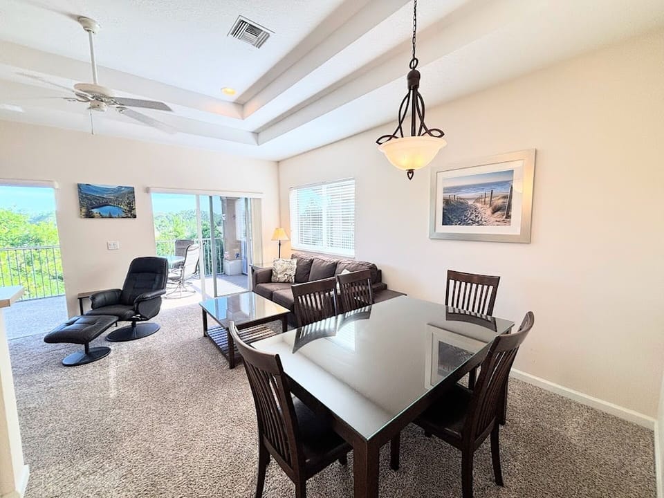 Inviting dining and living space with high ceilings, natural light, and easy access to the screened balcony.