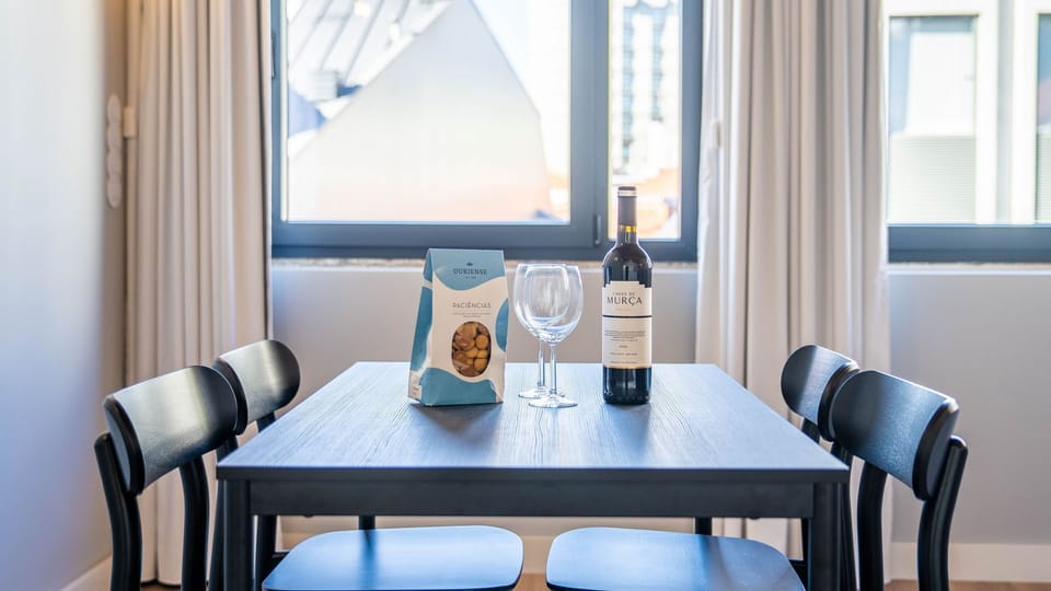 Savor a delightful evening with a glass of local wine and some thoughtful snacks at your inviting dining table, perfectly set for a relaxing moment. #WelcomeTreats #DiningExperience #LocalWine #SnackTime #RelaxingEvening #GuestReady #ComfortStay