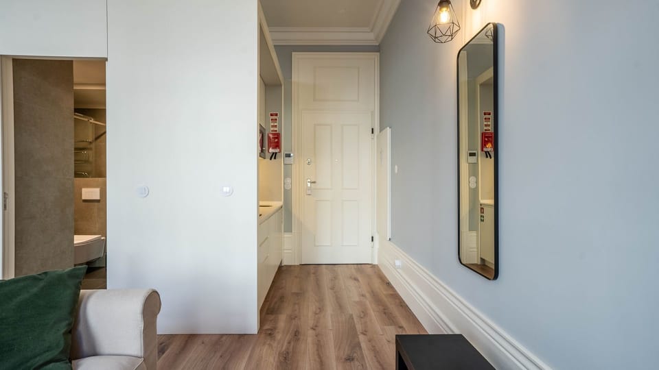 Experience modern elegance in the bathroom with a sleek floating marble sink and contemporary fixtures, perfect for refreshing after a day of exploring. Enjoy the convenience of wall-mounted dispensers providing essential toiletries for a comfortable stay