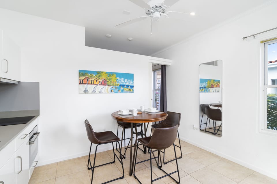 Lovely Dining Area of the Apartment in Noord Aruba - Chic dining area featuring a stylish furnish - Open layout seamlessly connecting the dining area to the kitchen and living room - Strategic use of mirrors to enhance the perception of space