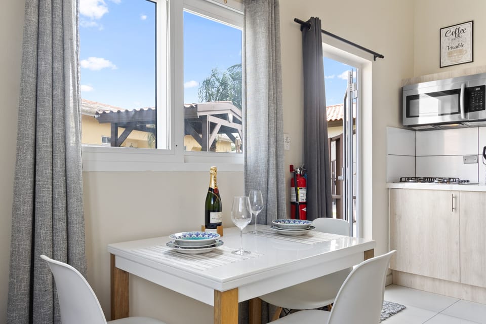 Marvelous dinning area of the apartment in Noord, Aruba - Beautiful window facing dinning area of the apartment - Elite 3 persons dinning - Stunningly located large windows with mesmerizing views - Majestic decored space with beautiful paintings