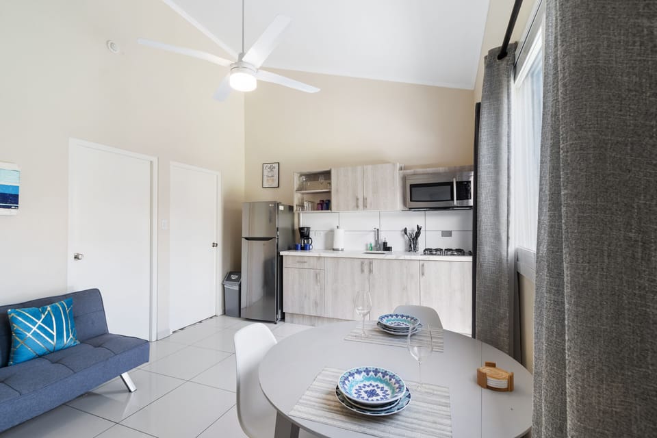 Pompous Dining and kitchen Area of the Apartment in Noord Aruba - Dining table for two and kitchen - Open layout seamlessly connecting the dining area to the kitchen and living room - Stylish dining space with chic furnishings