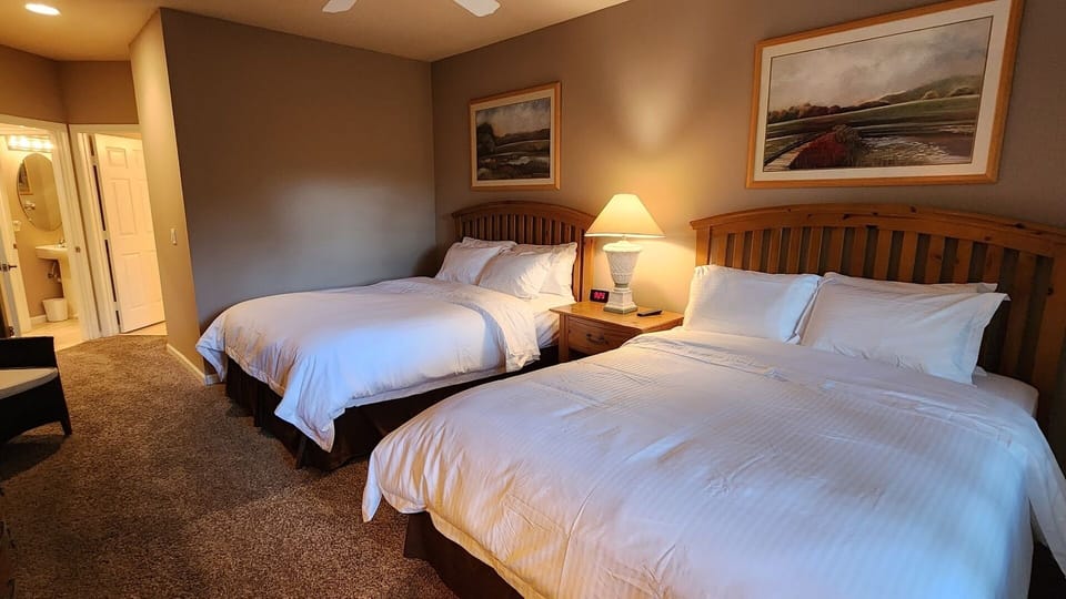 Spacious bedroom featuring two beds, bedside lighting, dresser storage, and a relaxing setup.