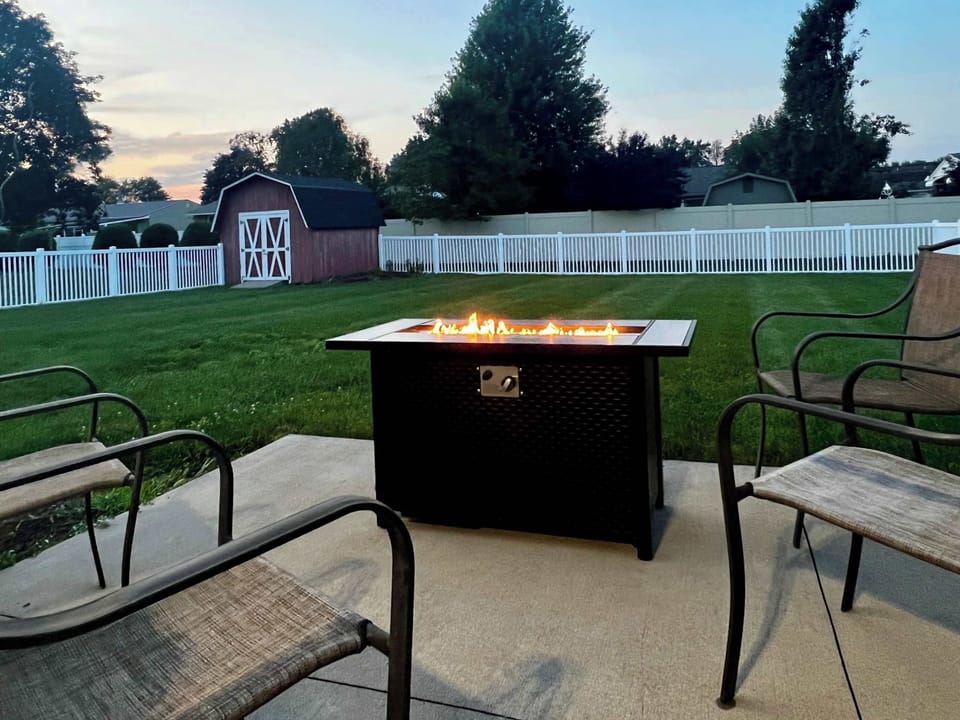 Fire pit in a fenced back yard create a cozy evening gathering spot. 