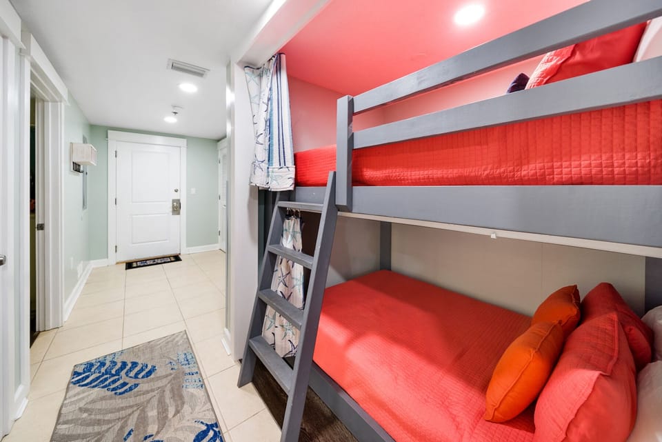 Your kids will love this vibrant bunk bed room with bold red bedding and playful design touches that make bedtime an adventure.