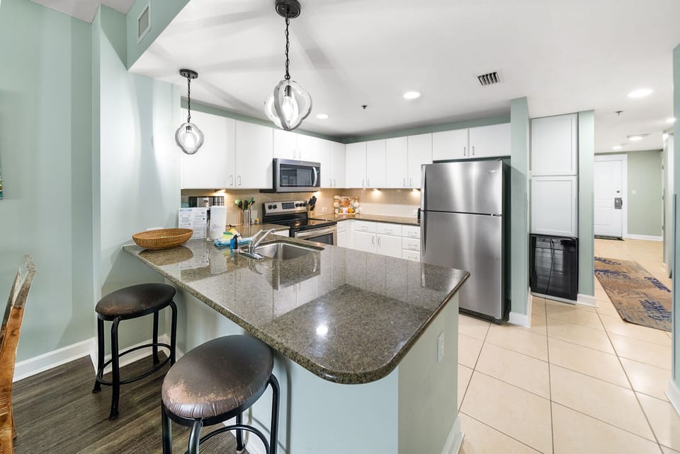 Your fully equipped kitchen features granite countertops, stainless steel appliances, and a breakfast bar where you can enjoy morning coffee.