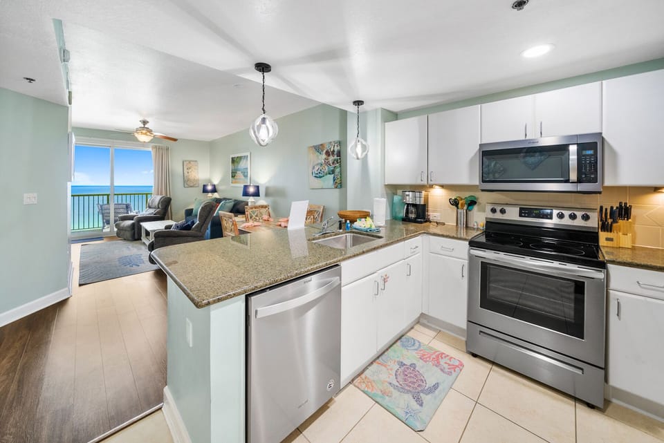 Your open-concept kitchen flows seamlessly into the living area, where ocean views create the perfect backdrop for morning coffee.